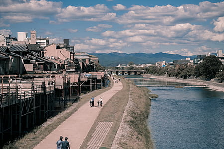 Two Person Walking Beside Body of Water thumbnail