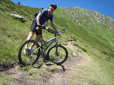 man holding his bike on a mountain steep thumbnail