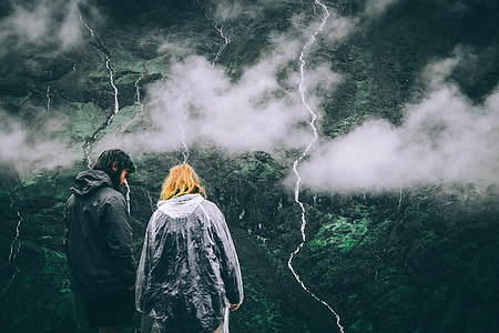 man and woman standing near mountain ranges thumbnail
