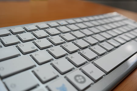 white computer keyboard on brown wooden surface thumbnail