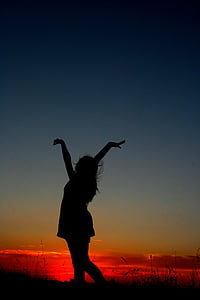 photography of woman raising her hands during sunset thumbnail