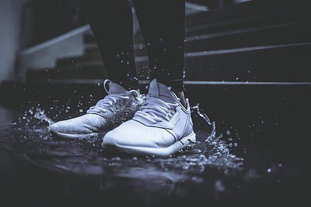 person wearing white running shoes standing floor with water thumbnail