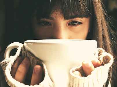 woman in sweater holding a ceramic cup thumbnail