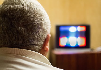 man in white shirt watching TV inside room thumbnail