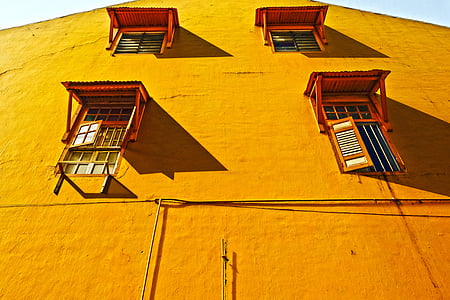 brown concrete wall with four windows during daytime thumbnail