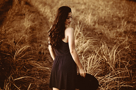 standing omen wearing black and white sleeveless dress thumbnail