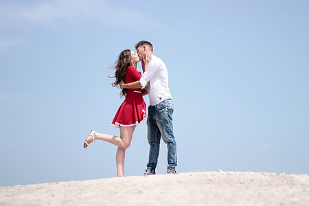 man and woman kissing while standing on white surface during daytime thumbnail