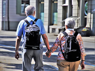 man and woman holding hands while walking on street thumbnail