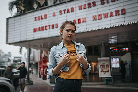woman standing near theater wearing blue denim jacket thumbnail