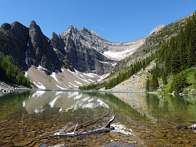 photo of body of water near mountain during daytime thumbnail