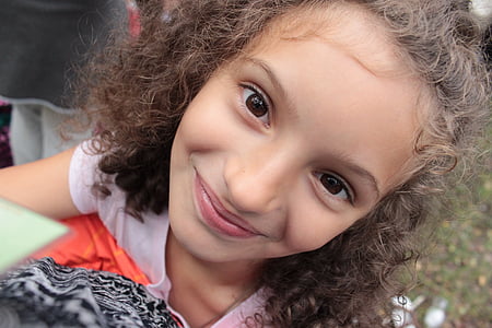 smiling girl in pink top in close-up photo thumbnail