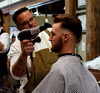 barber blow drying man's hair thumbnail