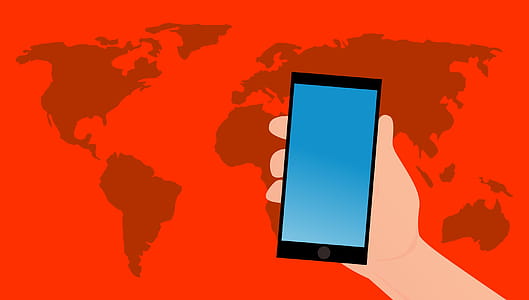 hand holding mobile device over map of the world thumbnail