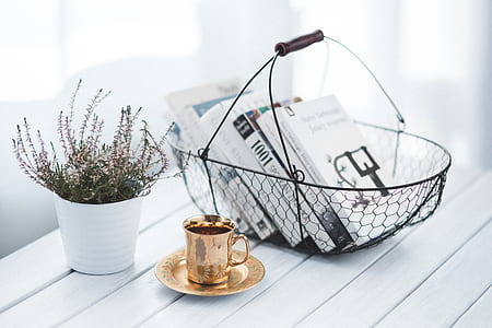 books on metal basket above wooden table thumbnail