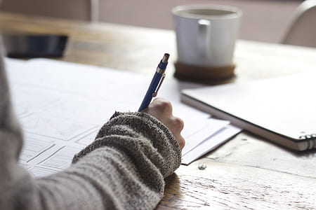 person writing something on white paper thumbnail