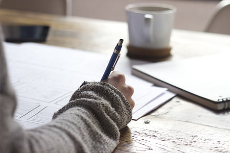 person using click pen on wooden table thumbnail