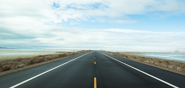 empty straight road under clouds thumbnail