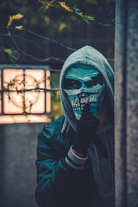 man wearing mask beside concrete wall thumbnail