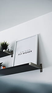 Aim High Fly Higher board placed on top of wall shelf thumbnail