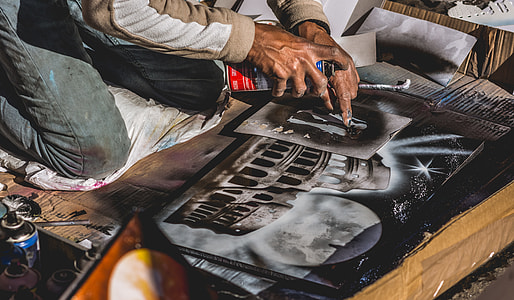person left index finger pointing on a concrete building printed photo on top of a table thumbnail
