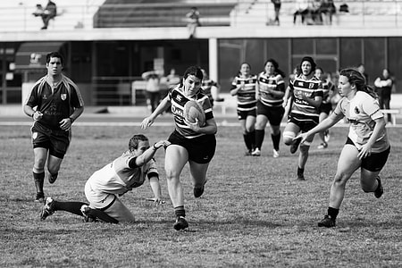 group of woman playing soccer in grayscale photo thumbnail