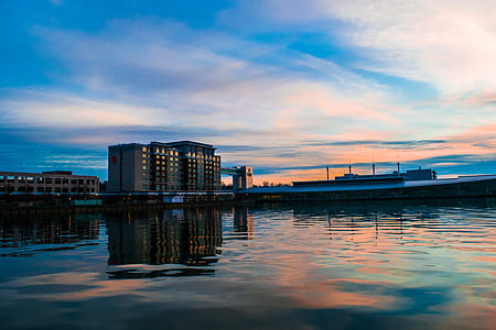 low-angle landscape photo of gray concrete building across body of water thumbnail