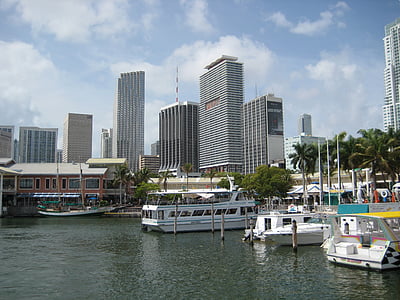 three boats on body of water near city buildings at daytime thumbnail