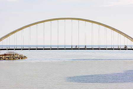 person riding bicycle on arch suspension bridge thumbnail
