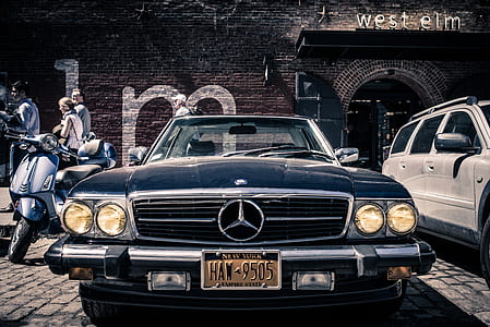classic black Mercedes-Benz car beside gray motor scooter thumbnail