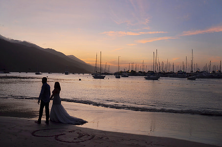 man and woman walking on seashore during sunset thumbnail