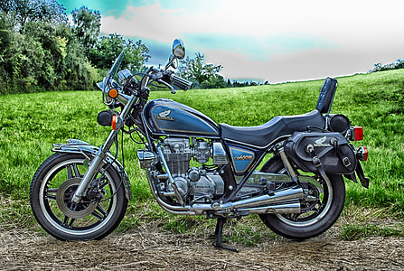 blue and black Honda cruiser motorcycle parked on green grass thumbnail
