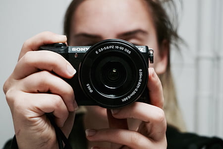 woman holding black Sony point-and-shoot camera thumbnail