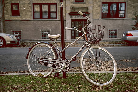 white and black city bicycle beside black steel pole thumbnail