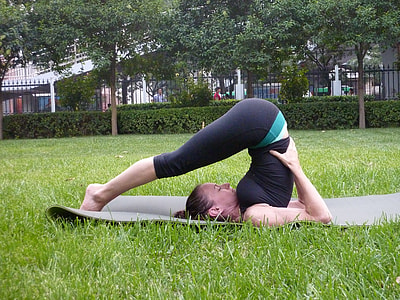 woman wearing black top and leggings bending on gray yoga mat thumbnail