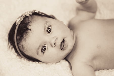 grayscale photography of baby lying on linen thumbnail