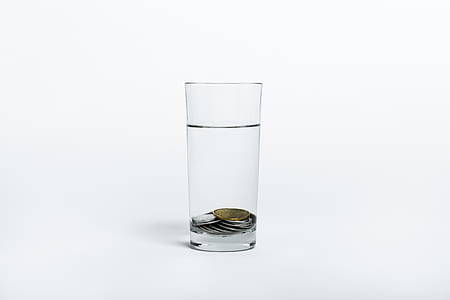 clear highball glass with coins and water thumbnail