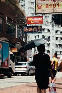 person under black umbrella outdoors thumbnail