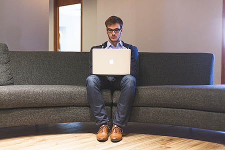 man sitting on sofa with MacBook on his lap thumbnail