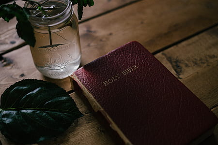 Holy Bible beside clear glass mason jar thumbnail