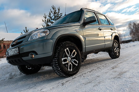 gray Chevrolet Captiva SUV on snowtrack under white cloud and blue sky thumbnail