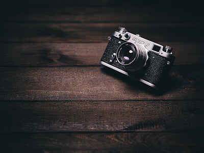 black and grey camera on brown wooden surface thumbnail