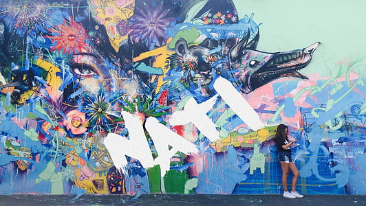 woman leaning in multicolored art wall thumbnail
