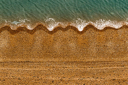 aerial photo of brown land beside body of water thumbnail