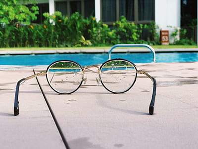 black framed eyeglasses near swimming pool at daytime thumbnail