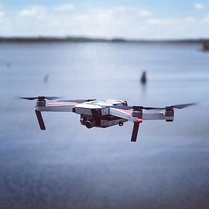 white and gray quadcopter drone flying on closeup photo thumbnail
