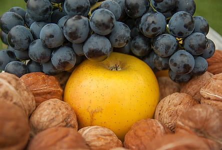 grapes on round yellow fruit surrounded by walnuts thumbnail