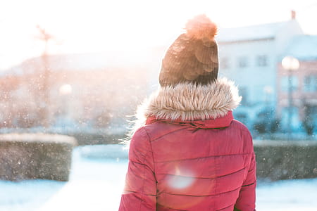 Woman Standing in Snowfall while Sun is Shining thumbnail