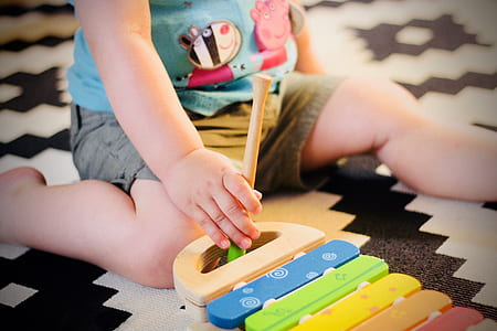 child squatting on floor playing xylophone thumbnail