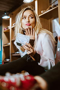 woman sitting on chair while holding mirror thumbnail