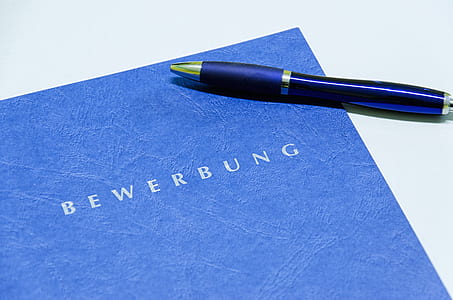 blue click pen on blue Bewerbung book thumbnail